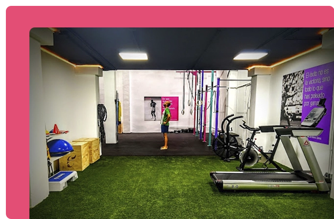 entrenador en el interior de gimnasio con máquinas y aparatos